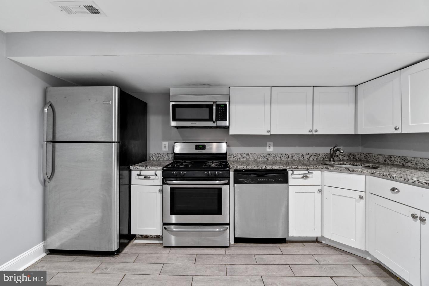 3416 Toone Street Baltimore, MD 21224 - Photo 3 of 18 a kitchen with stainless steel appliances granite countertop a stove a refrigerator and a granite counter tops