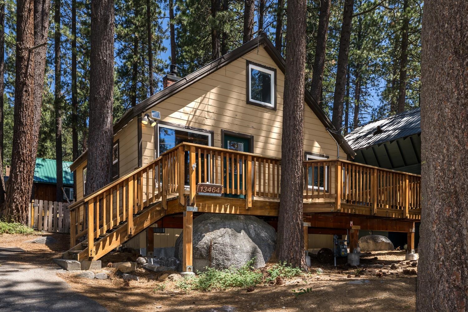 a view of a house with wooden deck next to a yard