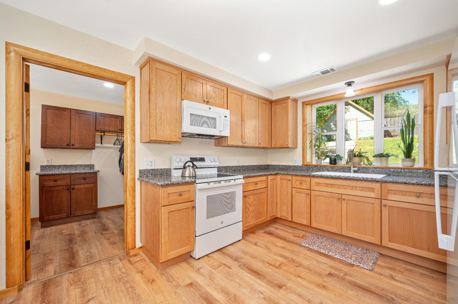 3240 Lone Star Mine Road Placerville, CA 95667 - Photo 22 of 59 a kitchen with stainless steel appliances granite countertop a stove top oven a sink dishwasher a dining table and chairs with wooden floor