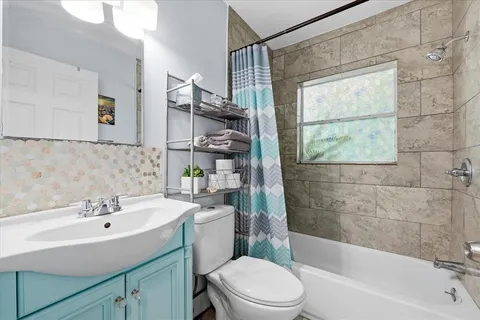 a bathroom with a sink mirror bathtub and toilet