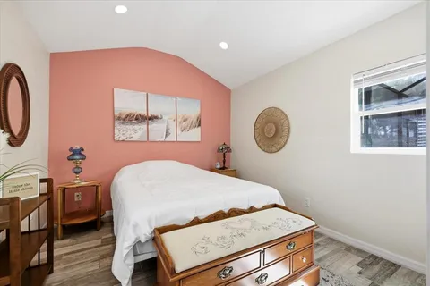 a bedroom with a bed and a lamp on dresser