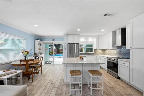 a large kitchen with kitchen island a dining table and chairs