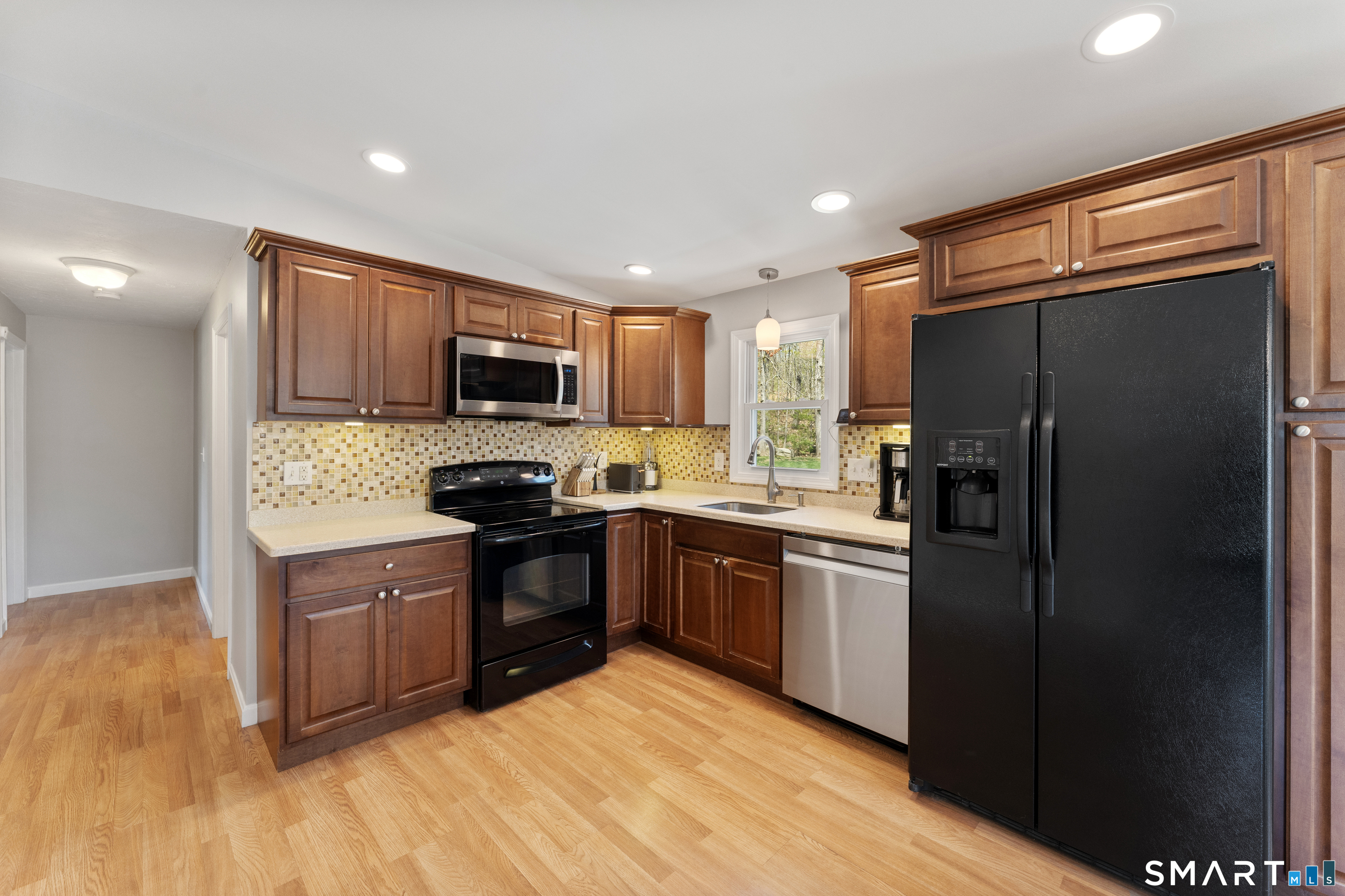 56 Thompson Hill Road Thompson, CT 06255 - Photo 11 of 38 a kitchen with granite countertop stainless steel appliances and wooden cabinets
