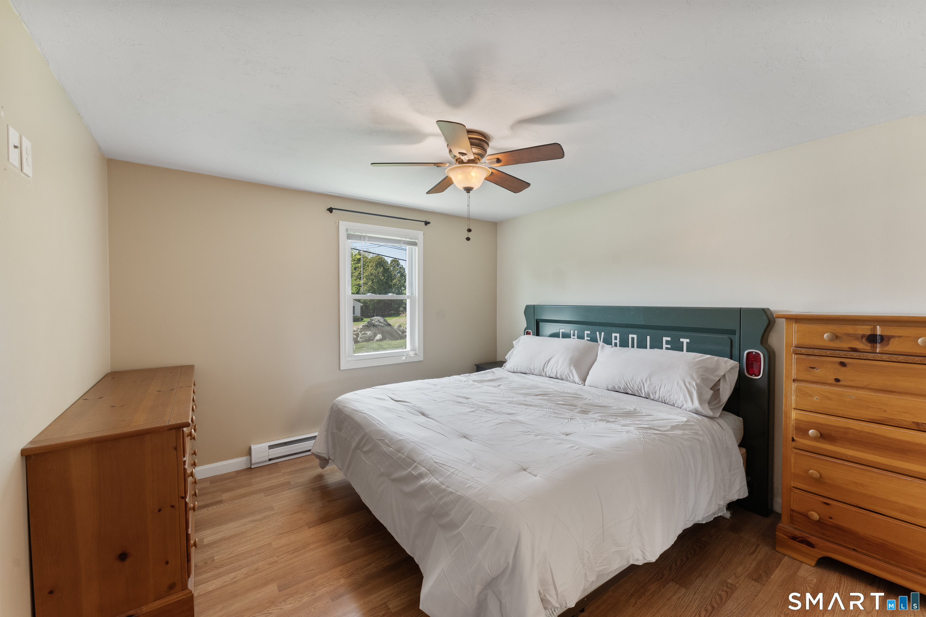 56 Thompson Hill Road Thompson, CT 06255 - Photo 20 of 38 a bedroom with a bed and a chandelier
