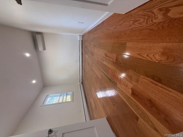 90-19 107th Avenue, Unit 2 Queens, NY 11417 - Photo 2 of 12 an empty room with wooden floor and windows
