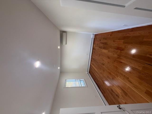 90-19 107th Avenue, Unit 2 Queens, NY 11417 - Photo 6 of 12 an empty room with wooden floor and windows