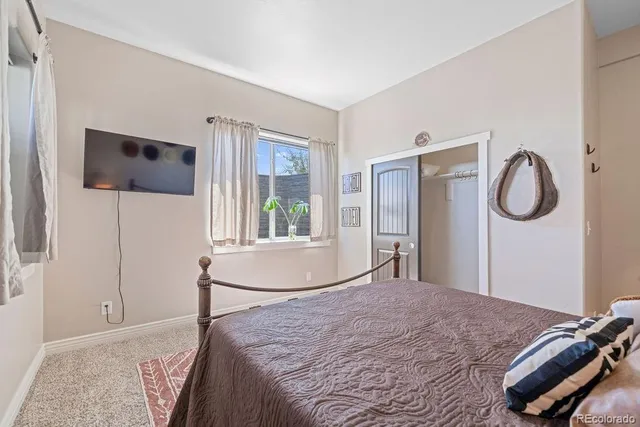 a bedroom with a bed and a large window