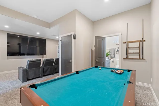 a room with pool table and stairs