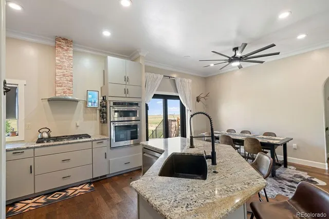 a kitchen with stainless steel appliances granite countertop a sink a stove and a refrigerator