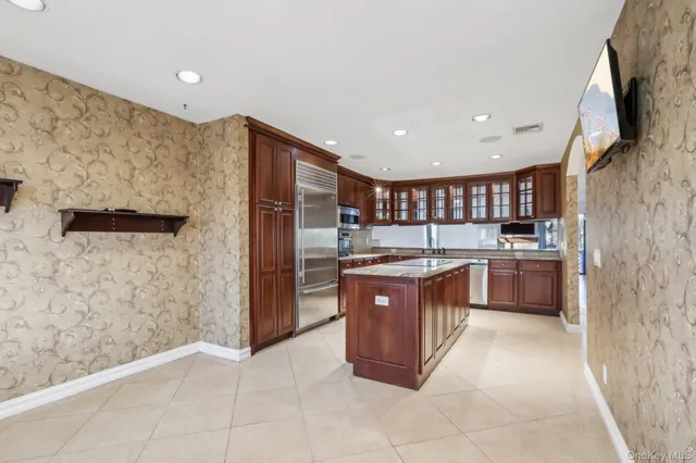 a large kitchen with stainless steel appliances granite countertop a stove a sink and a refrigerator