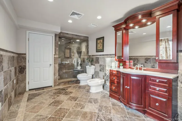 a bathroom with a double vanity sink toilet and shower