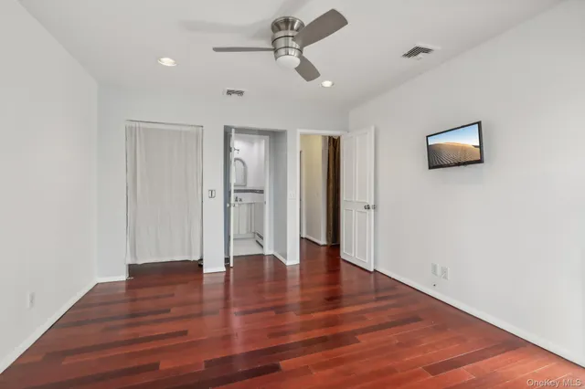 a view of an empty room with wooden floor