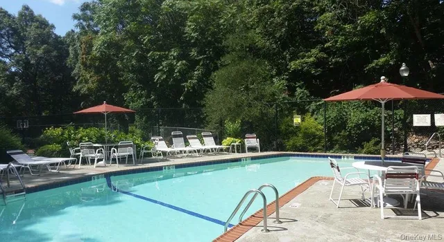 a view of a swimming pool with a table and chairs under an umbrella