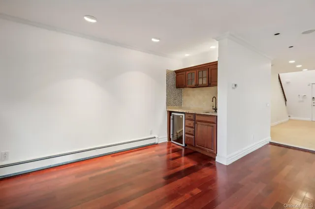 a view of an empty room with wooden floor and a cabinet