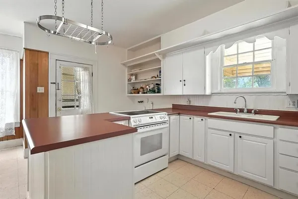 a kitchen with cabinets appliances and a window
