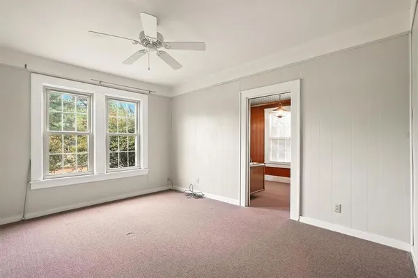 an empty room with windows and closet area