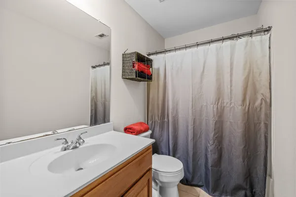 a bathroom with a sink toilet and shower curtain