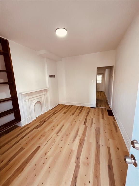 5144 Natrona Way Pittsburgh, PA 15201 - Photo 2 of 11 a view of a bedroom with wooden floor and staircase