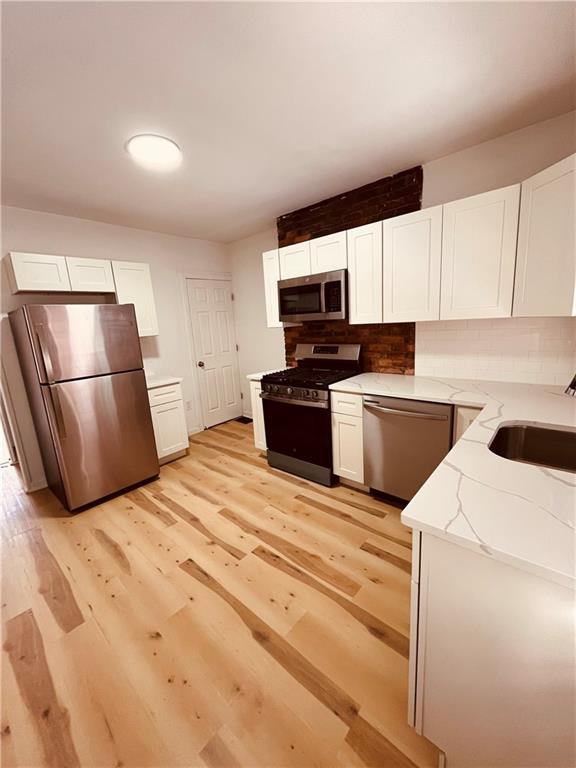 5144 Natrona Way Pittsburgh, PA 15201 - Photo 3 of 11 a kitchen with a refrigerator sink and wooden cabinets