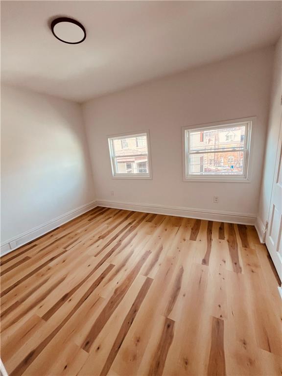 5144 Natrona Way Pittsburgh, PA 15201 - Photo 6 of 11 an empty room with wooden floor and windows