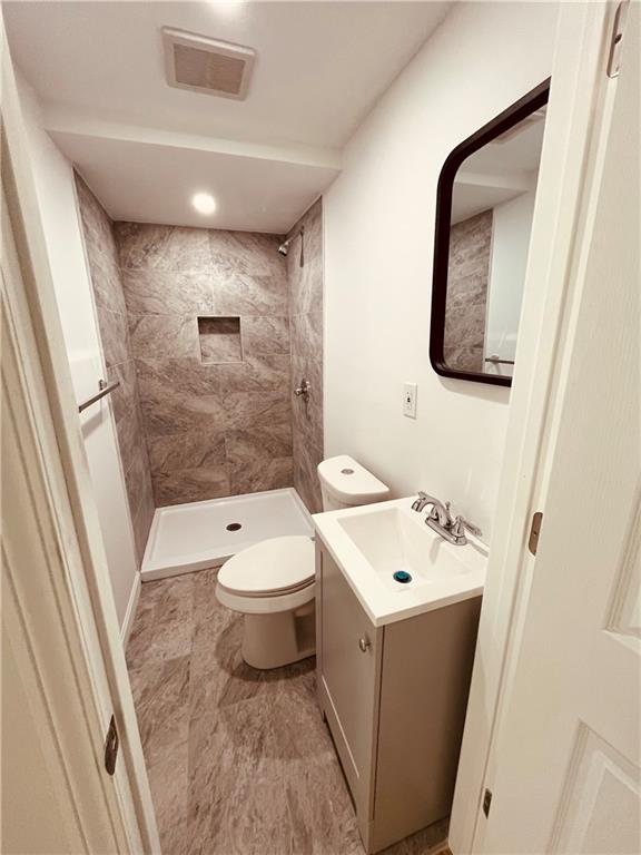 5144 Natrona Way Pittsburgh, PA 15201 - Photo 9 of 11 a bathroom with a toilet sink and mirror