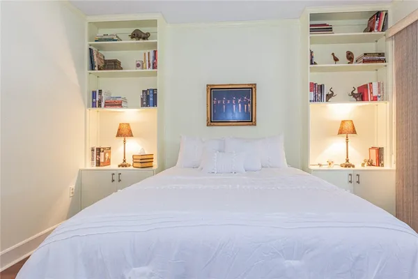 a bedroom with a bed and a painting on the wall