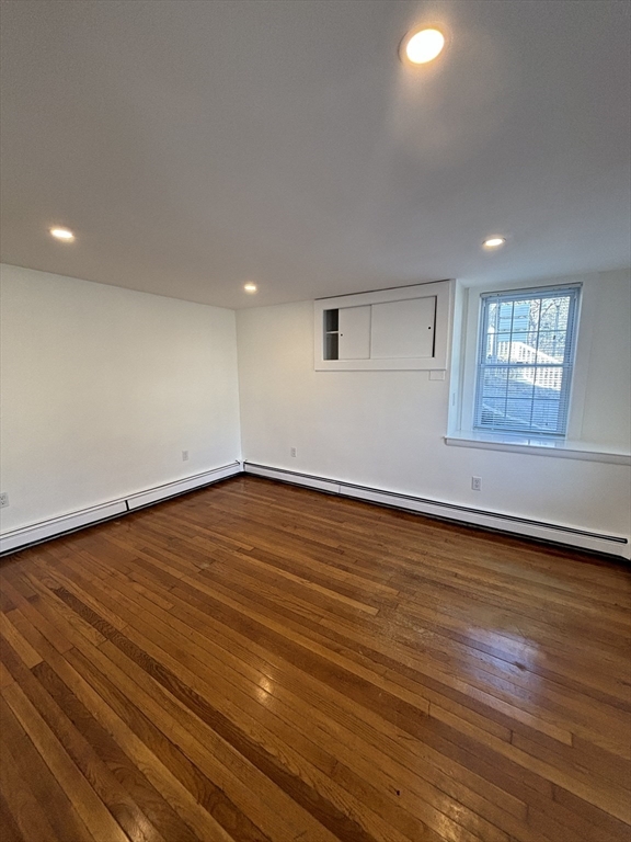 79 Pleasant Street, Unit 1 Stoneham, MA 02180 - Photo 1 of 7 an empty room with wooden floor and windows