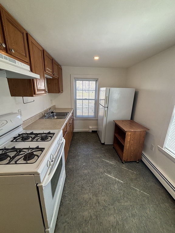 79 Pleasant Street, Unit 1 Stoneham, MA 02180 - Photo 2 of 7 a kitchen with granite countertop a stove and a microwave