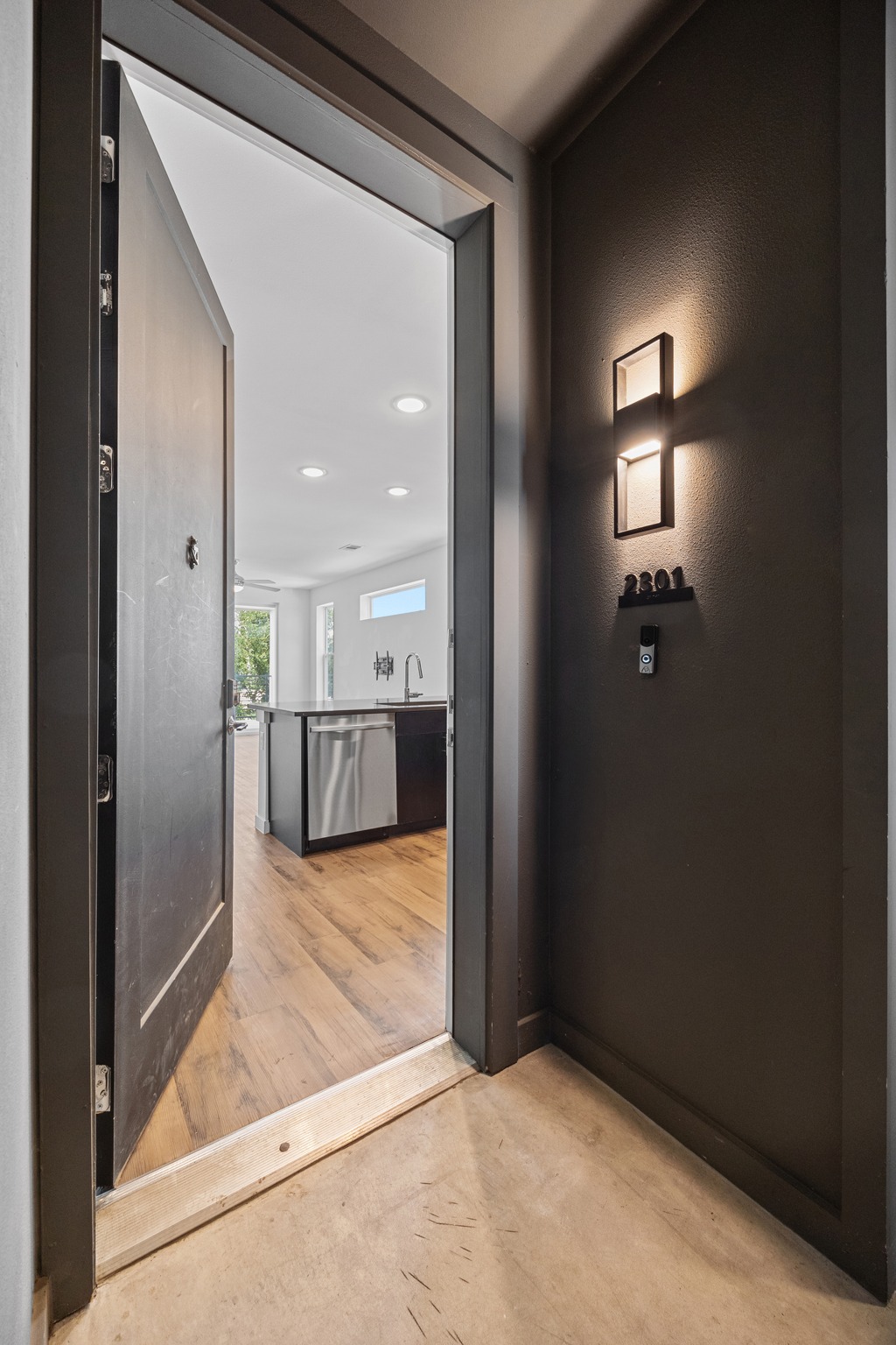 4801 Springdale Road, Unit 2301 Austin, TX 78723 - Photo 4 of 36 Step through the entry to an inviting kitchen with sleek appliances and warm wood floors.