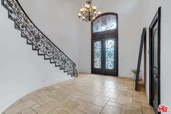 a view of a hallway with windows and chandelier