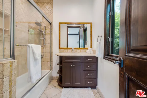 a bathroom with a sink a mirror and a shower
