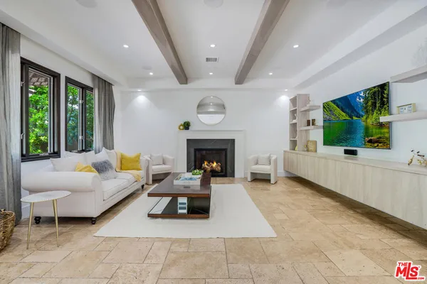 a living room with furniture large window and a fireplace