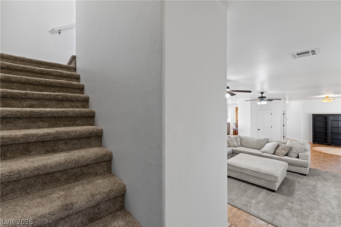 575 Gann Avenue Logandale, NV 89021 - Photo 38 of 75 Carpeted stairs ascend to a private upper level, adjacent to a living space featuring recessed lighting.