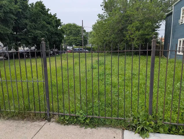 a view of a swimming pool with a bench and trees around