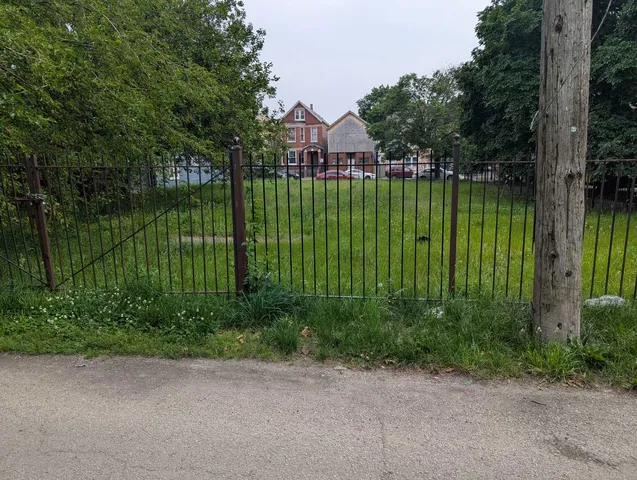 a view of a lake with a big yard and large trees