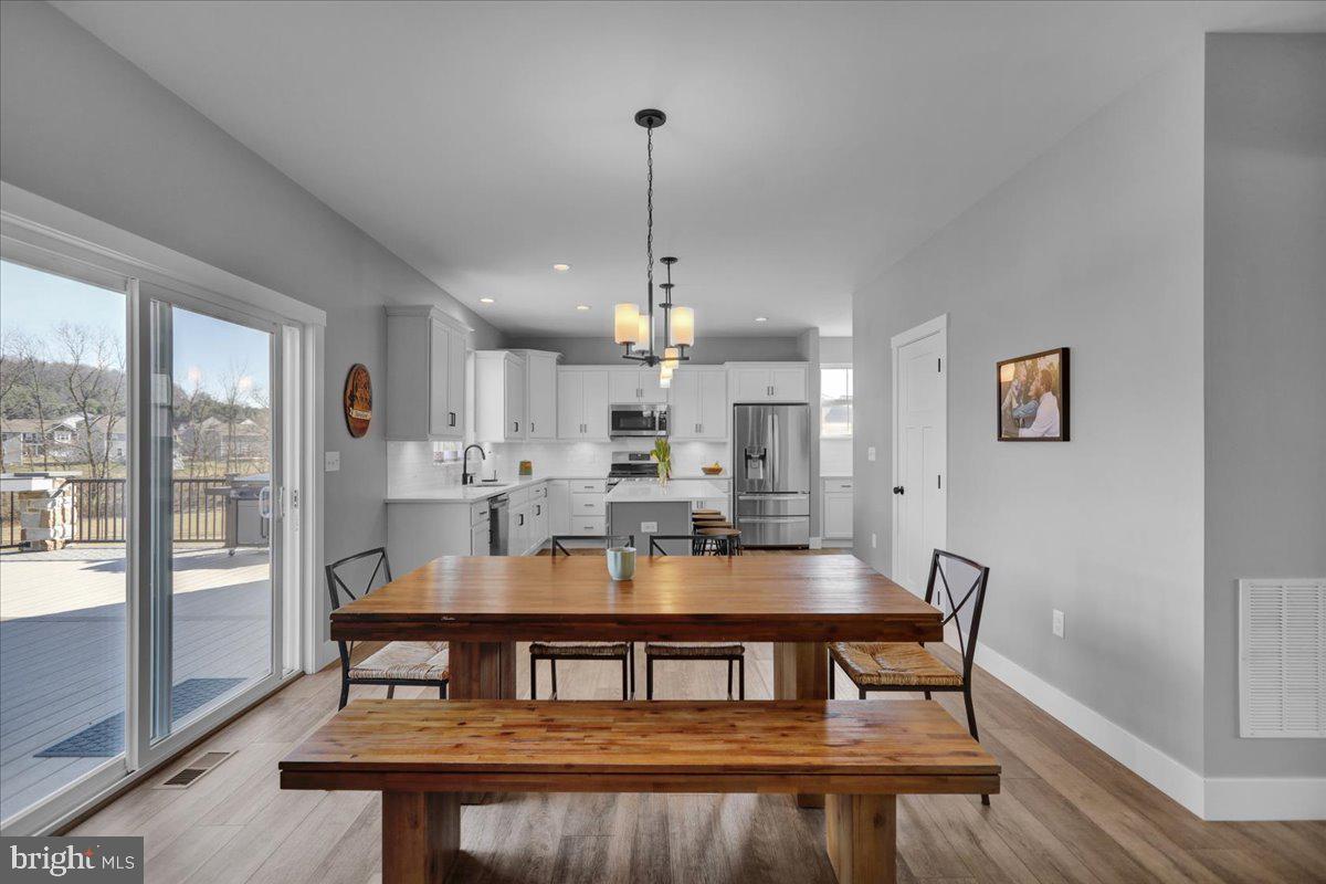 1057 Ryebrook Road Reading, PA 19608 - Photo 15 of 49 a dining room with furniture a chandelier and wooden floor