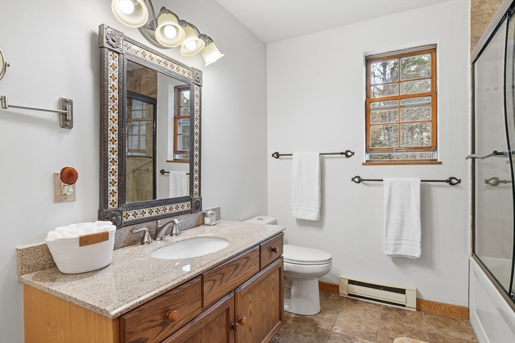 359 Montague Road Shutesbury, MA 01072 - Photo 21 of 38 a bathroom with a granite countertop sink a toilet and a mirror