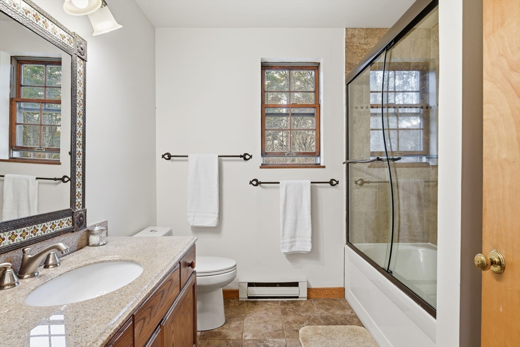 359 Montague Road Shutesbury, MA 01072 - Photo 22 of 38 a bathroom with a granite countertop sink a toilet and shower