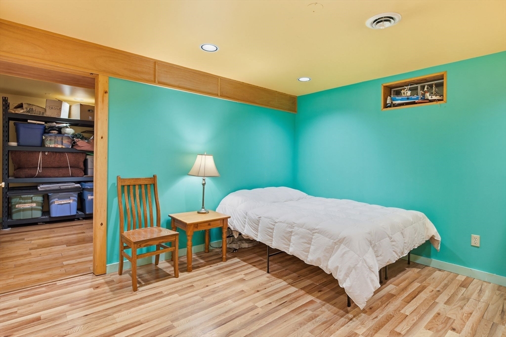 359 Montague Road Shutesbury, MA 01072 - Photo 27 of 38 a bedroom with a bed a table and chair