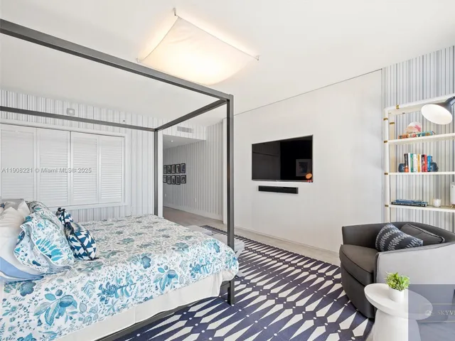 a bedroom with a bed and a flat screen tv