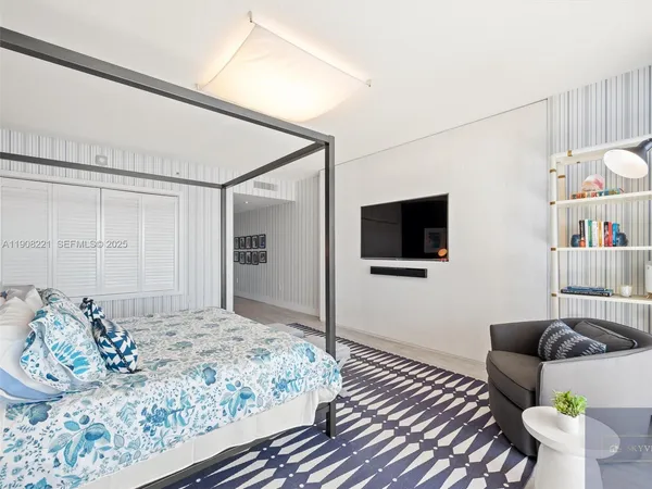 a bedroom with a bed and a flat screen tv