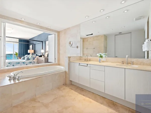 a spacious bathroom with a double vanity sink mirror and bathtub