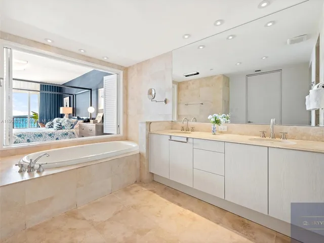 a spacious bathroom with a double vanity sink mirror and bathtub