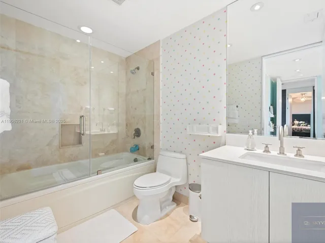 a bathroom with a sink a toilet and a large mirror