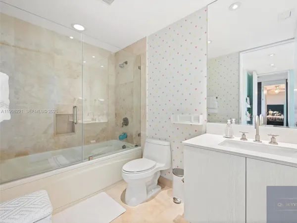 a bathroom with a sink a toilet and a large mirror