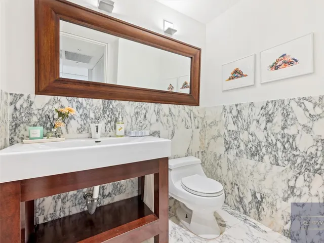 a bathroom with a toilet a sink and a mirror