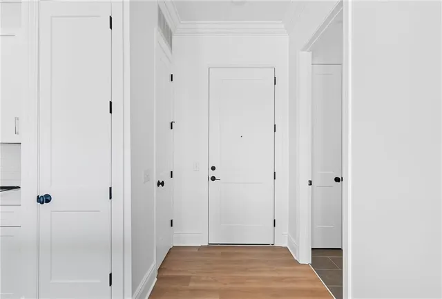 a large kitchen with stainless steel appliances granite countertop a stove a sink dishwasher and white cabinets with wooden floor