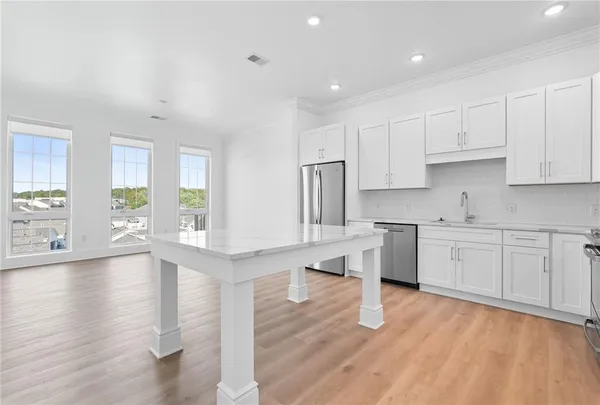 a kitchen with stainless steel appliances granite countertop a sink stove and white cabinets
