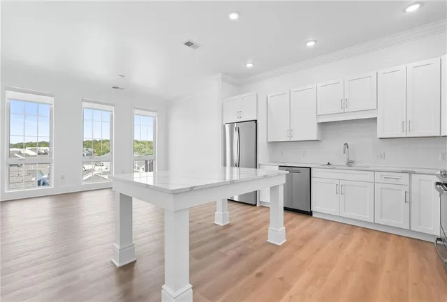 a kitchen with stainless steel appliances granite countertop a sink stove and white cabinets