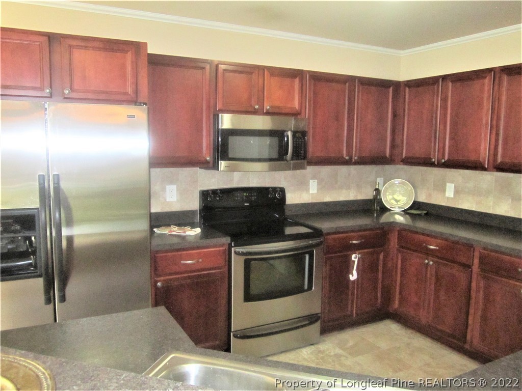 558 Cape Fear Road Raeford, NC 28376 - Photo 3 of 10 a kitchen with stainless steel appliances granite countertop a stove a refrigerator and a sink
